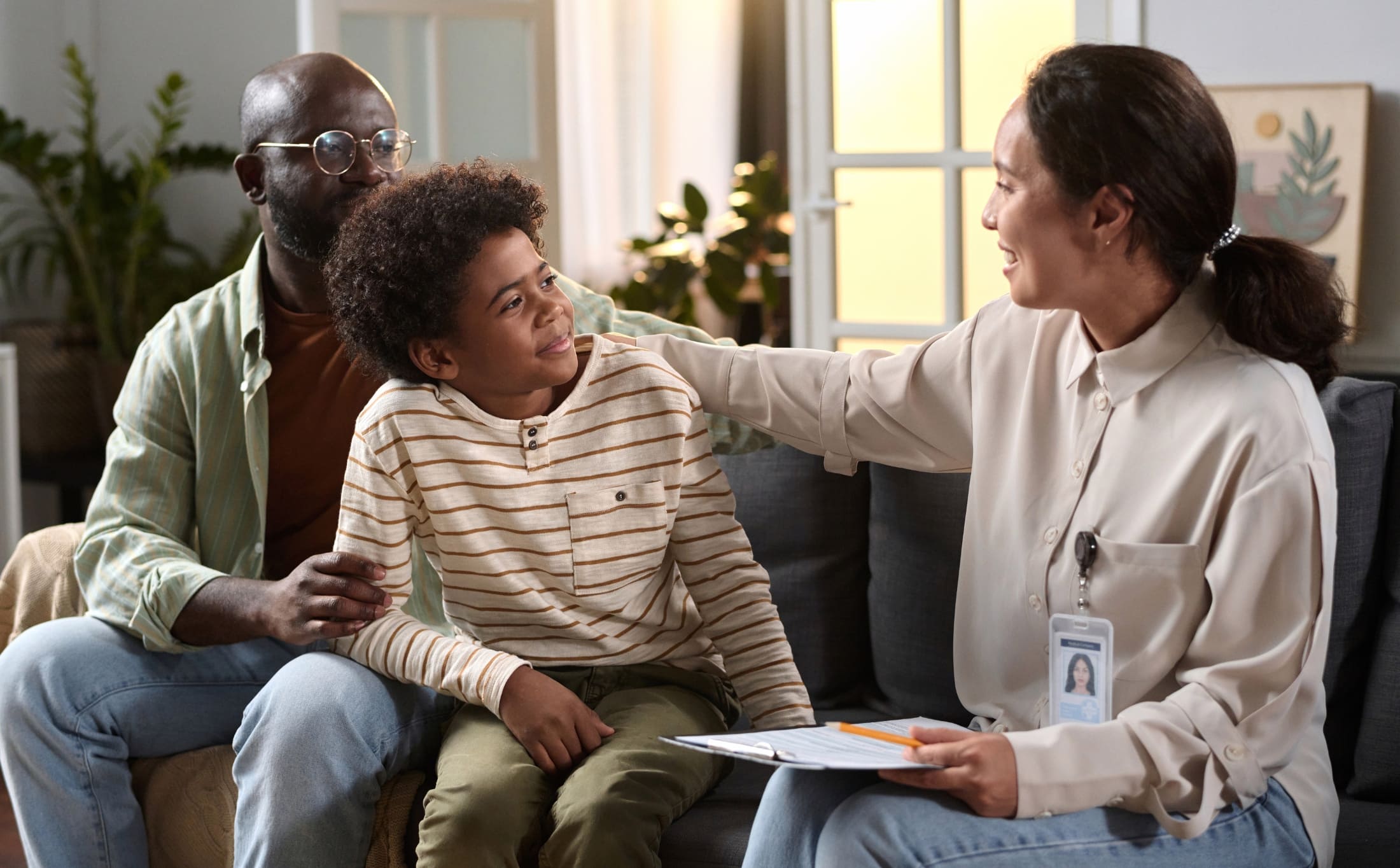 A professional supports a teen and father in an adolescent psychiatry session in Raleigh.