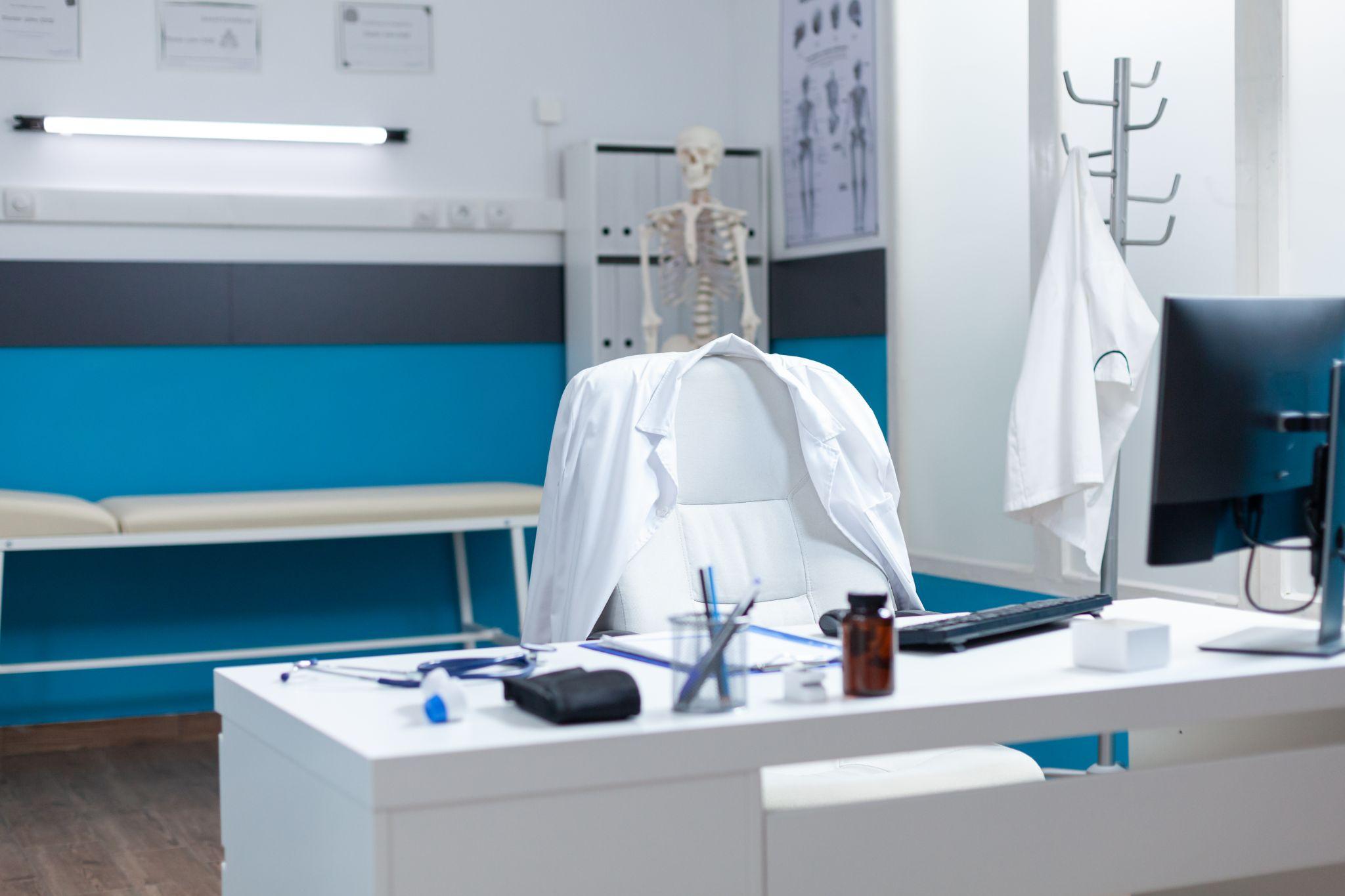 A clean medical workspace equipped with diagnostic tools and anatomical charts, prepared for a patient consultation with no people present.