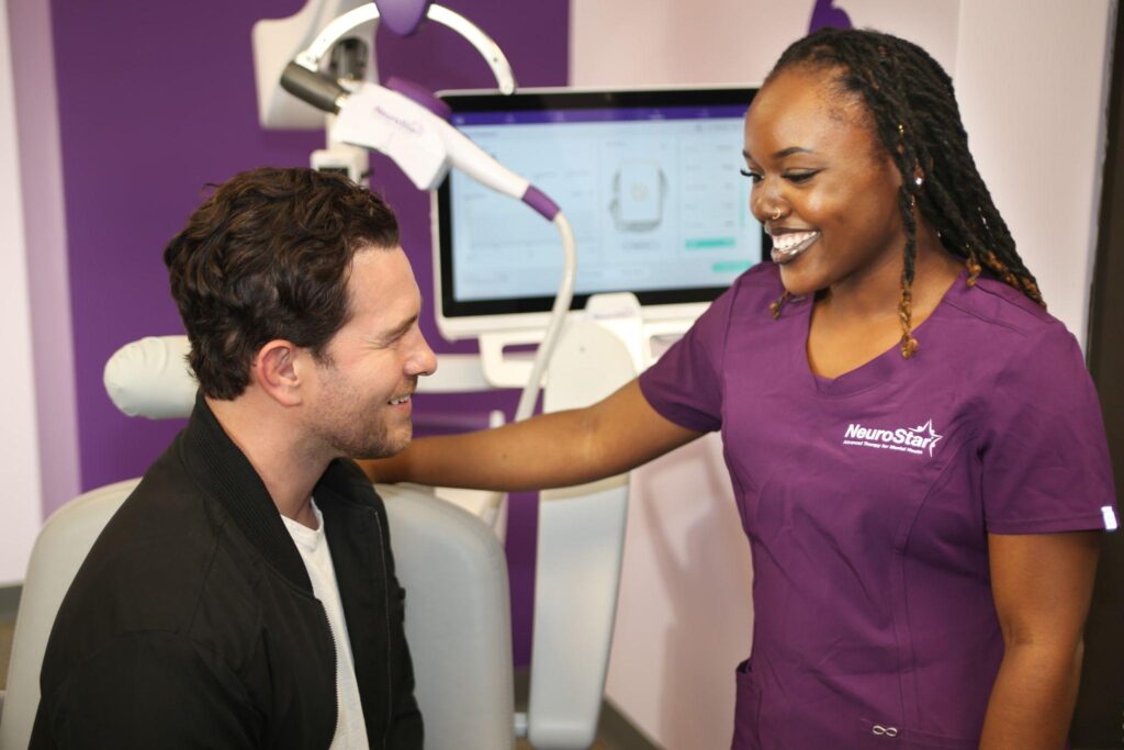 Clinician and patient smiling after a TMS therapy session for bipolar disorder management.